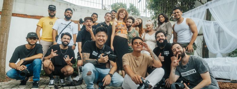 Group of people practicing tree pose in a sunlit room.